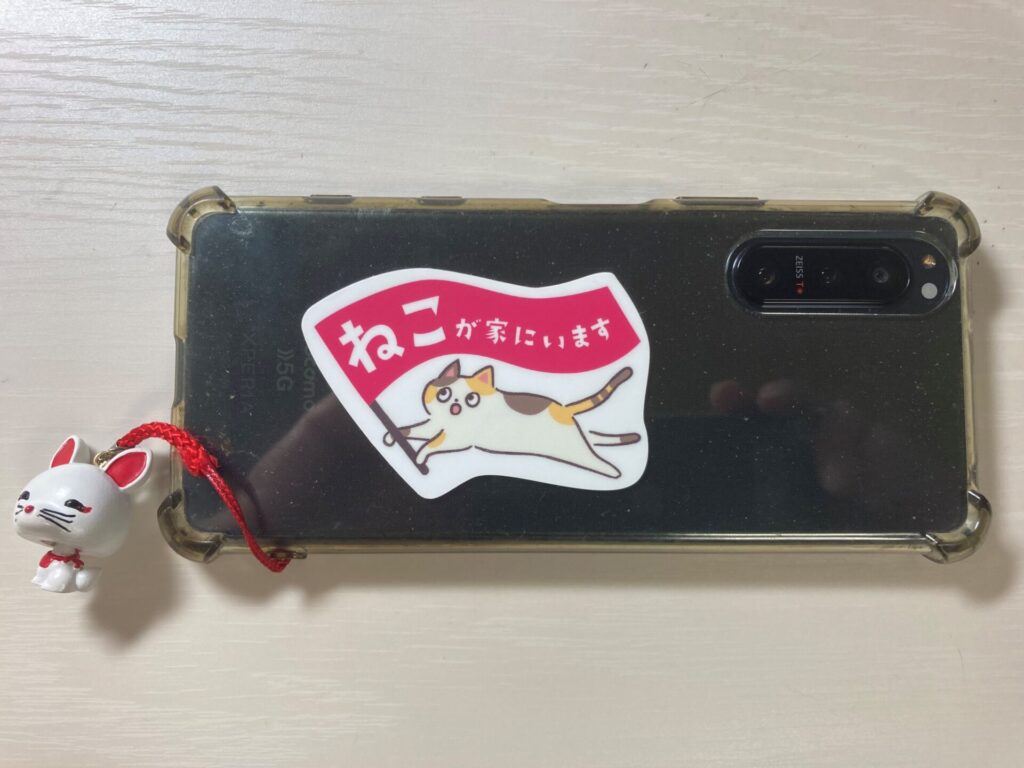 ねこがいますステッカーを張った自分のスマートフォン